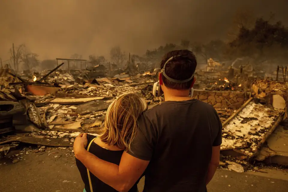 Megan Mantia, left, and her boyfriend Thomas, return to Mantia's fire-damaged home after the Eaton Fire swept through Jan. 8, 2025 in Altadena, Calif. (AP Photo/Ethan Swope)